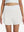 Front lower body shot of model wearing white women's gym golf shorts with liner pocket
