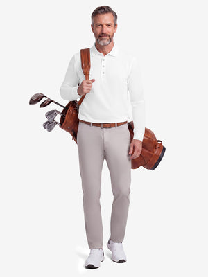 Front full body shot of model wearing white solid stretch cotton pique long sleeve polo shirt while carrying a golf bag on back