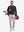 Front full body shot of model wearing dark navy solid stretch cotton pique long sleeve polo shirt while carrying a golf bag on back