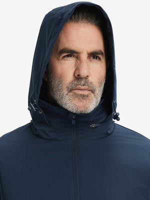 Close-up of hood on the lightweight water-repellent softshell hooded jacket, worn by model in navy.
