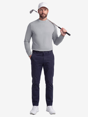 Front full body shot of model wearing grey warm brushed mock neck golf t shirt with golf club resting on shoulder