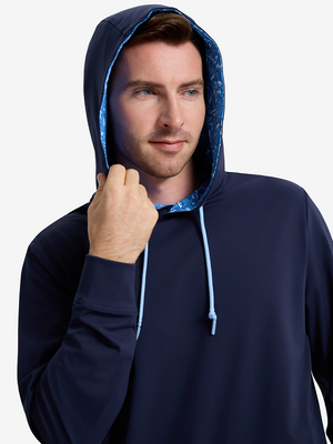 Front upper body shot of model wearing navy soft stretchy hoodie with inner print hood and pulling the hood with one hand