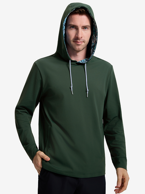 Front upper body shot of model wearing forest green soft stretchy hoodie with inner print hood with one hand in pants pocket