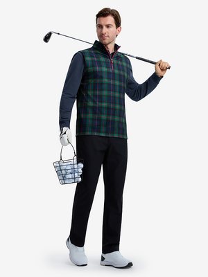 Front full body shot of model wearing dark plaid full print quarter zip sleeveless vest pullover with a golf club resting on shoulder in one hand and holding a basket of golf balls in the other hand