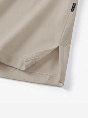 Detail view of hem on light khaki solid stretch cotton pique long sleeve polo shirts