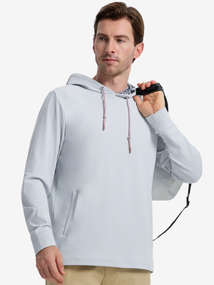Front upper body shot of model wearing misty blue soft stretchy hoodie with inner print hood while carrying a golf bag in one hand