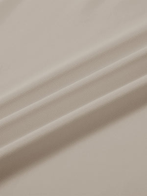 Close-up texture of  light khaki solid stretch cotton pique long sleeve polo shirts fabric showing detailed premium material and weave