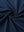 Close-up of navy 4 way stretch jacquard polo fabric texture highlighting intricate woven pattern and elasticity.