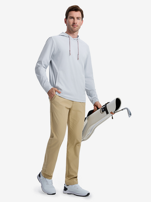 Front full body shot of model wearing misty blue soft stretchy hoodie with inner print hood while carrying a golf bag in one hand