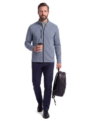 Front full body shot of model wearing sand warm brushed mock neck golf t shirt, carrying a bag in one hand and holding a coffee cup in the other hand