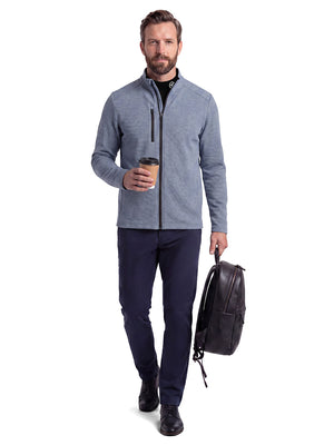 Front full body shot of model wearing black warm brushed mock neck golf t shirt, carrying a bag in one hand and holding a coffee cup in the other hand