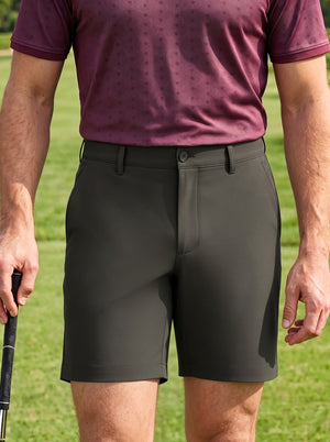 Front mid-length shot of male model wearing tea brown flat front hybrid golf shorts on the golf course with one hand holding a golf club