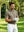 Front upper body angled shot of model wearing taupe heather performance heather contrast collar polo shirt and adjusting gloves with both hands on the golf course