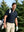 Front upper body angled shot of male model wearing navy ultra-comfort slim fit roma knit polo shirt with golf bag on back  on the golf course