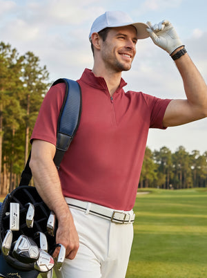 Front upper body angled shot of male model wearing brick red waffle texture 1/4 zip pullover with golf bag and looking into the distance on the golf course